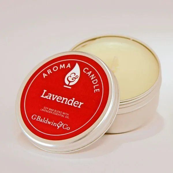 Round silver tin of G. Baldwin & Co. Lavender Aroma Candle with a red label, featuring a soy wax blend with lavender essential oil.