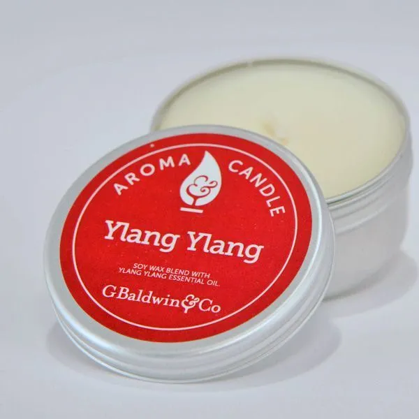 Silver tin of G. Baldwin & Co. Ylang Ylang Aroma Candle with a red label, featuring a soy wax blend with ylang-ylang essential oil.